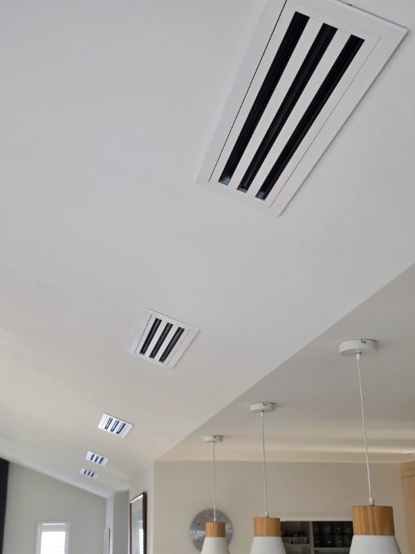 A white linear slot diffuser set into the raked ceiling of a finished Otago home