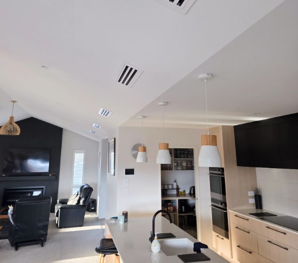 A ducted heating system in a finished open-plan kitchen and living room in Otago, with the ceiling diffusers barely visible