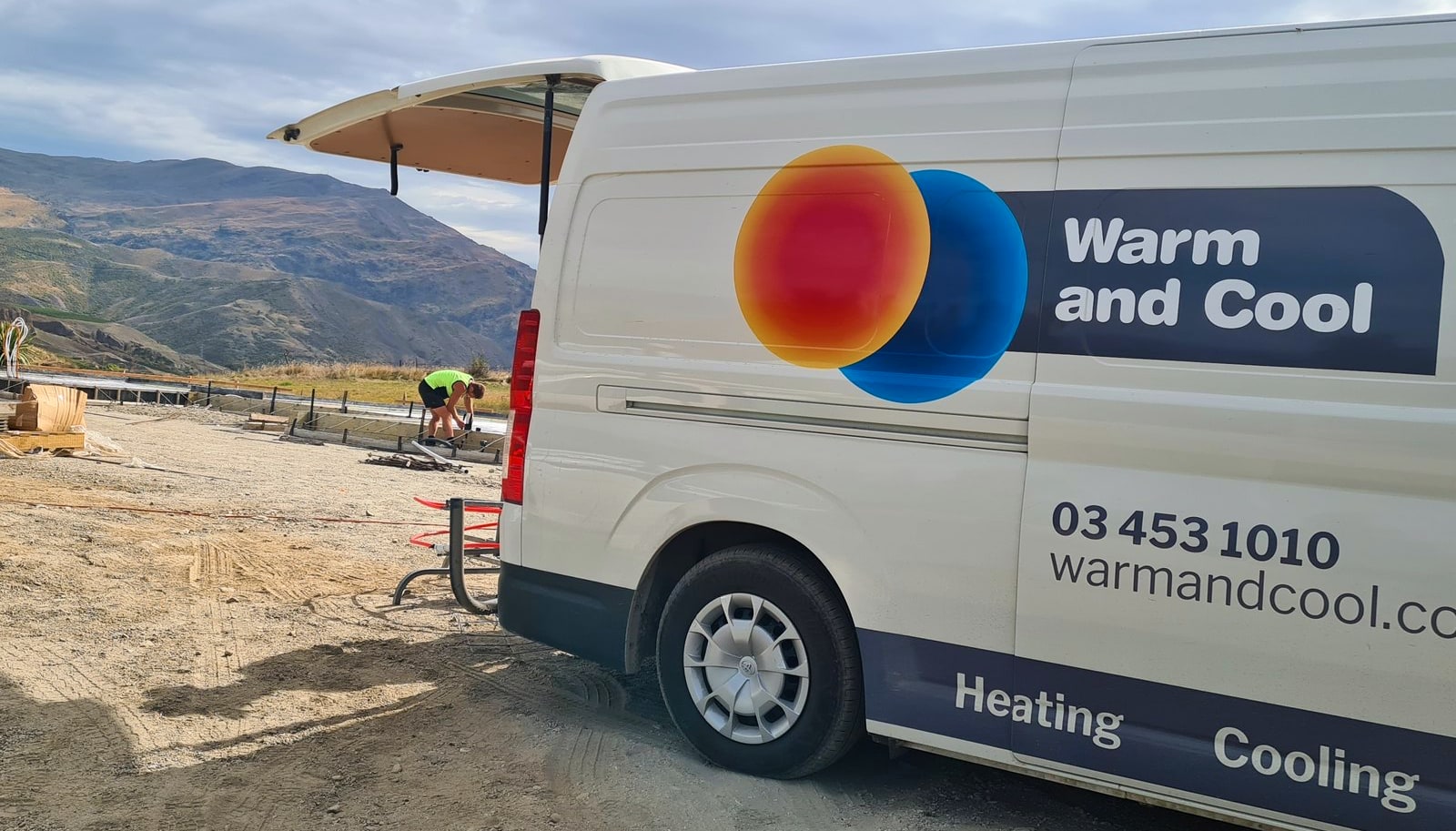 A Warm and Cool van on site at a Central Otago heating installation, with the hills behind