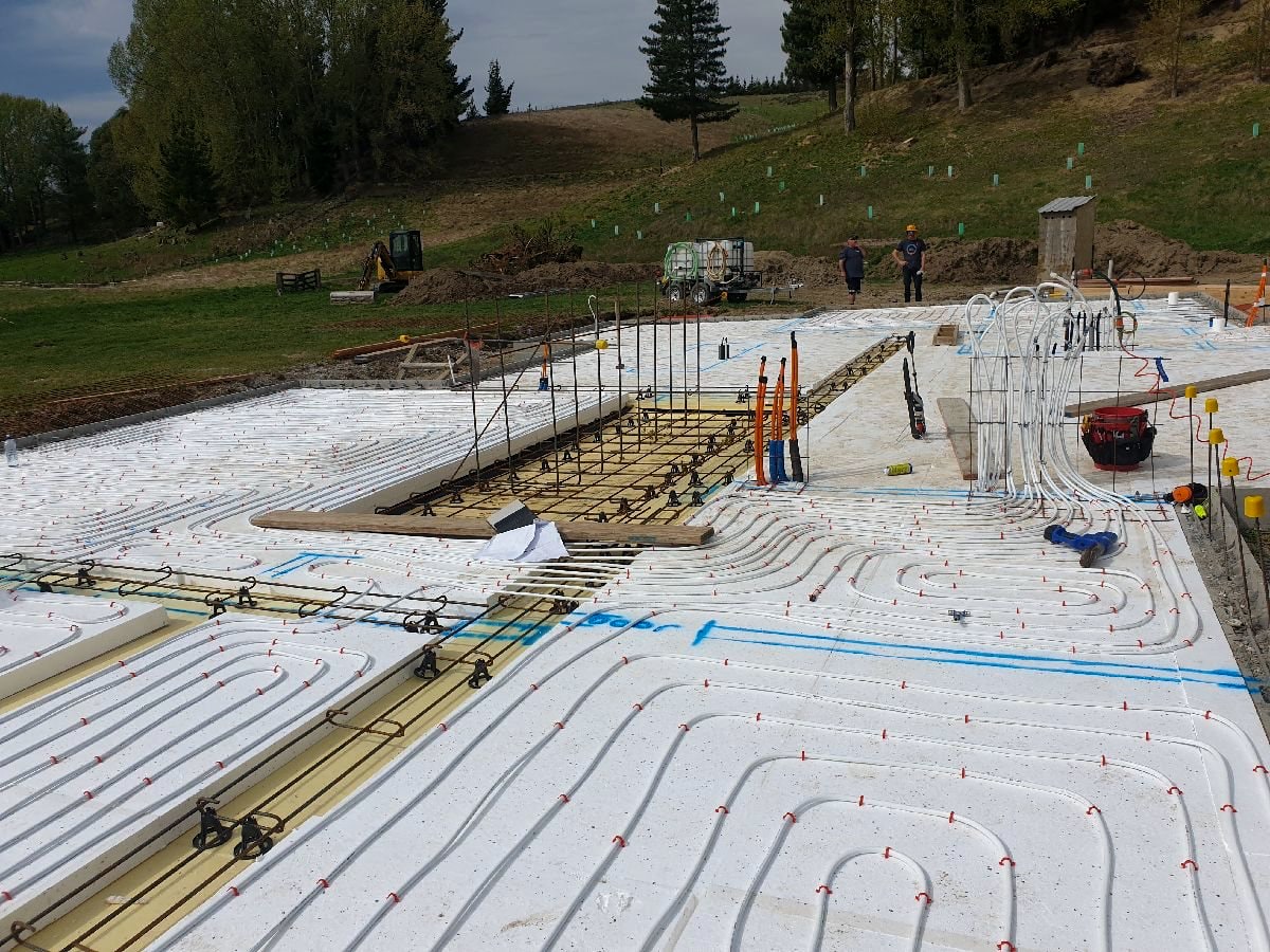 Hydronic underfloor heating loops laid out across a new build slab in rural Otago before the pour